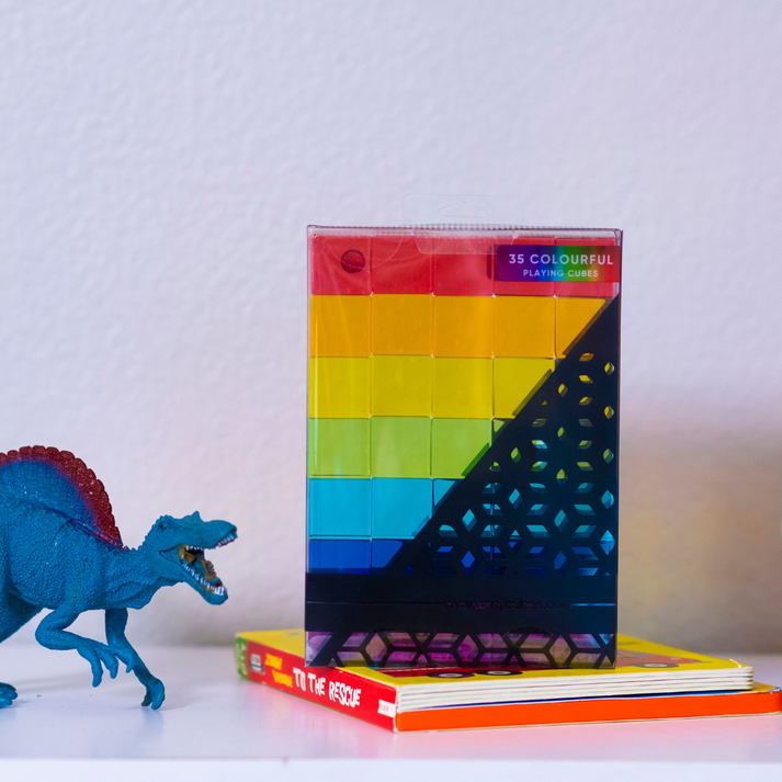 plato's cubes translucent Platonic-style cubes arranged in a rainbow gradient on a black retail box, photographed at an angle on a gray background. The box shows the brand name 'eCubes' at the top and 'Plato's Cubes' at the bottom.