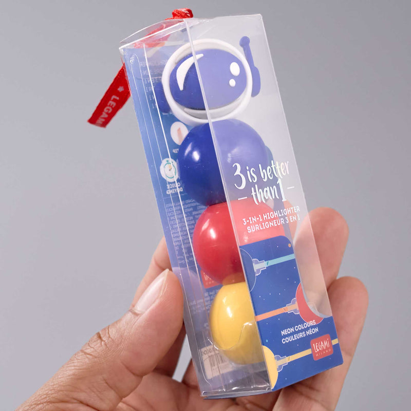 Hand holding a colorful 3-in-1 highlighter set with packaging against a gray background