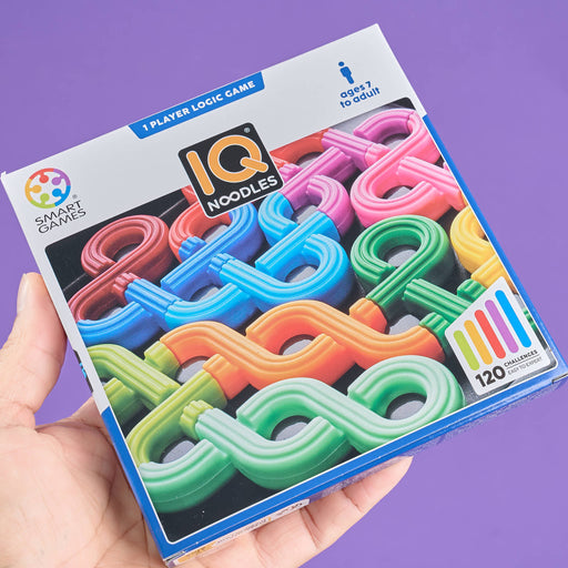 IQ Noodles game packaging held by a hand with a purple background
