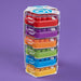 Set of colorful plastic containers stacked in a tower on a purple background