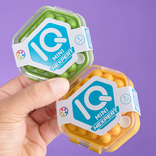 Two containers of IQ Mini Hexpert snacks held by a hand against a purple background