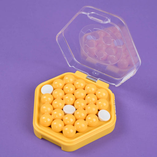 Hexagonal yellow container with white beads on a purple background