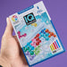 IQ Bubbles game box held by a hand with a purple background