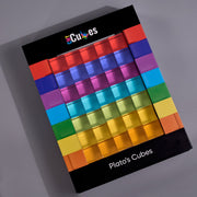 A boxed set of plato's cubes translucent Platonic-style cubes arranged in a rainbow gradient on a black retail box, photographed at an angle on a gray background. The box shows the brand name 'eCubes' at the top and 'Plato's Cubes' at the bottom.