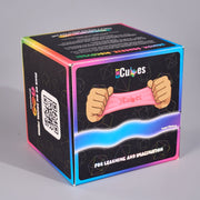 A cube-shaped product box for 'CMY Cubes' featuring a black front panel with an illustration of hands stretching a pink elastic band, surrounded by a vibrant iridescent rainbow border on a neutral gray background.
