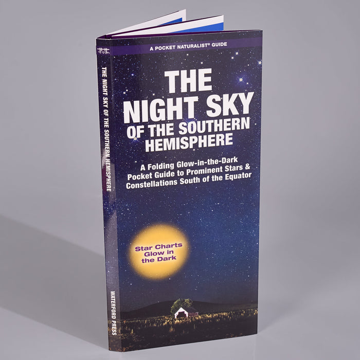 A pocket guide book titled 'The Night Sky of the Southern Hemisphere' standing upright on a neutral gray background. The cover features a starry night sky design with a glowing moon and a small house at the bottom, and the title is printed in large white letters.