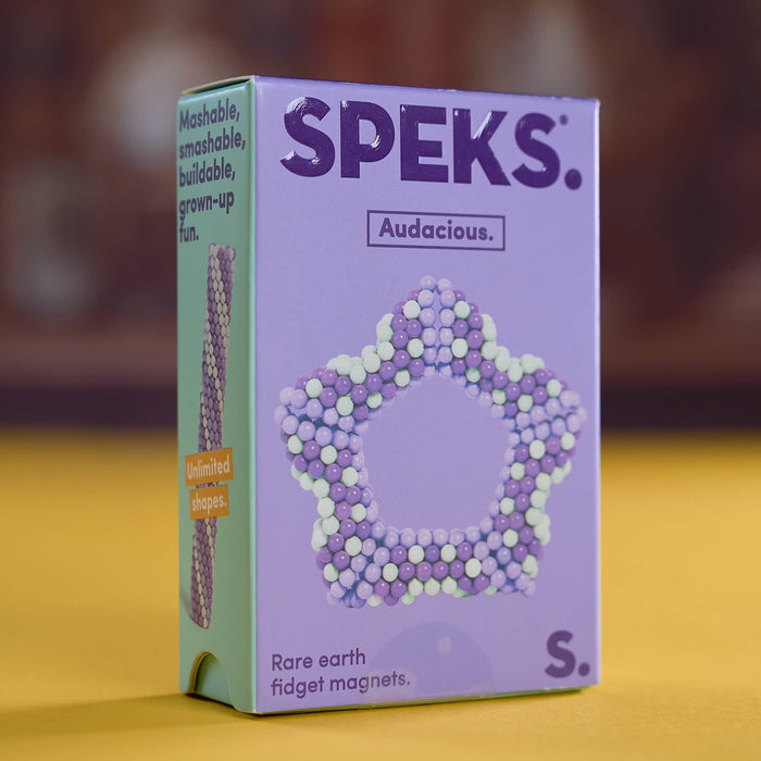 A box of SPEKS. Audacious fidget magnets, size S, featuring a lavender and mint green package with a star-shaped magnet design made of purple and white beads.