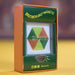 A boxed toy or educational magnetic bead set standing upright on a yellow surface. The package is orange and dark green with yellow text reading 'SPECTACULARLY MAGNETIC' and a clear window showing a hexagonal bead arrangement in green, yellow, and orange.