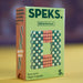 A box of SPEKS. fidget magnets, featuring a light green front with a colorful magnetic bead design and an orange side panel with product text, set against a blurred yellow and purple background.