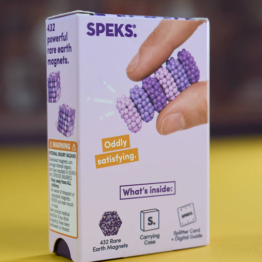 A box of SPEKS Rare Earth Magnets, showing the front and side panels with product details, a photo of fingers holding a purple magnetic bead bracelet, and text describing the contents.