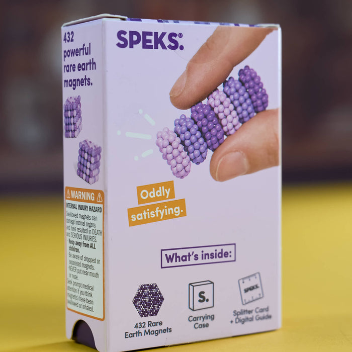 A box of SPEKS Rare Earth Magnets, showing the front and side panels with product details, a photo of fingers holding a purple magnetic bead bracelet, and text describing the contents.
