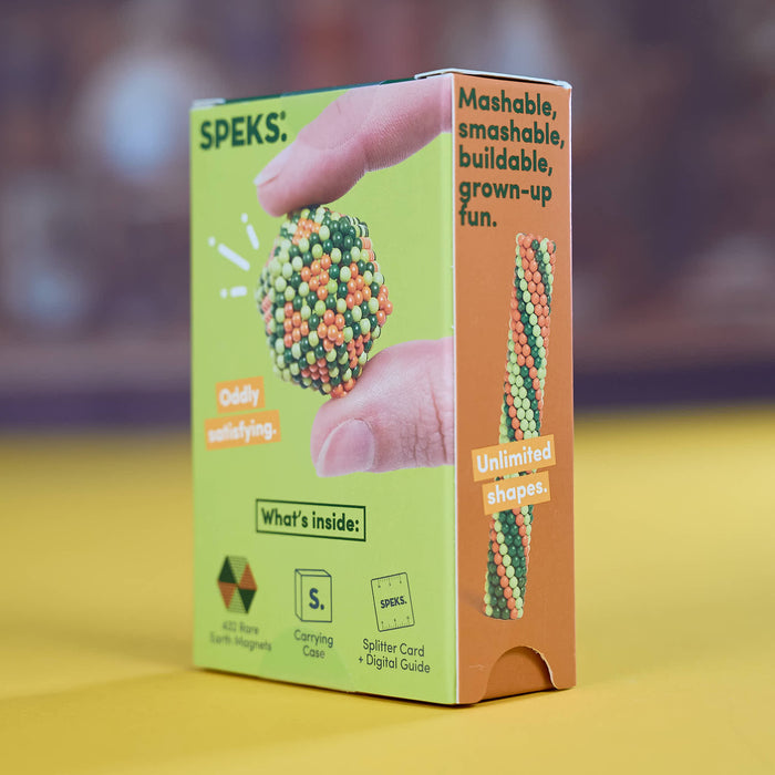 Speks Mashable Earth Magneets product box, featuring a bright lime green and orange design with a demonstration of hands holding a small, colorful, spherical magnet.