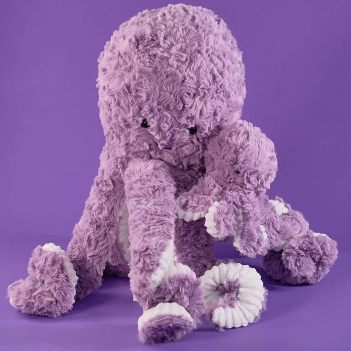 Purple plush octopus, soft fluffy texture, lavender color, cute smiling face, long tentacles, white rope-detail accents, cuddly stuffed toy, raised display, close-up product focus.