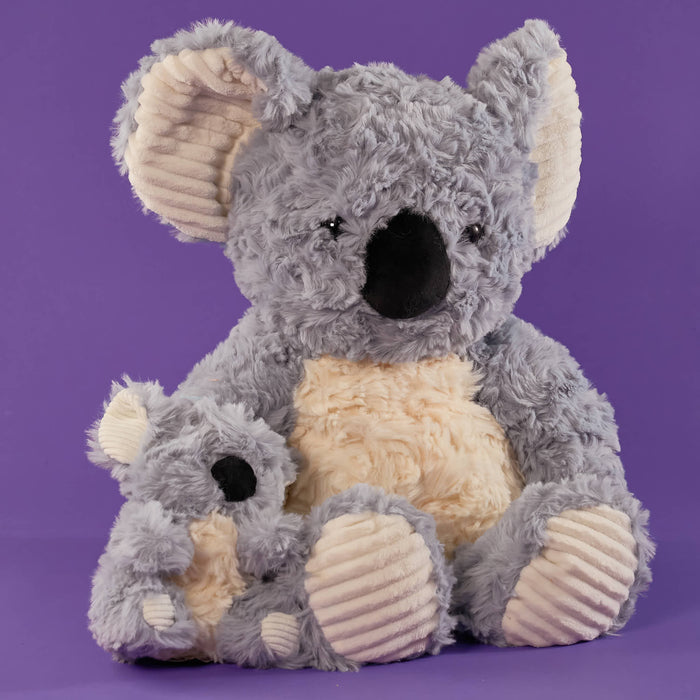 Grey koala plush toy, soft fluffy texture, cream belly and inner ears, large black nose, cute cuddly design, matching baby koala plush, cosy bedroom setting, warm soft lighting, Australian animal stuffed toy.
