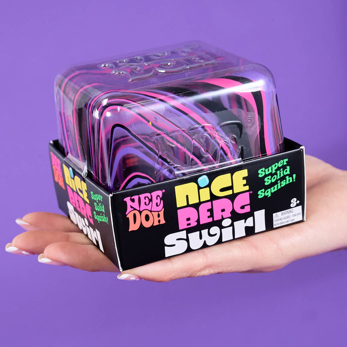 A hand holding a packaged toy product labeled 'Nice Berg Swirl' against a solid purple background. The product is a squishy toy inside a clear plastic clamshell package with a black branded cardboard base.