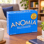A blue box of Anomia card game, sealed in clear plastic wrap,  The box features the game's title in large white letters, along with a gold Mensa Select stamp.
