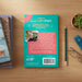 The back cover of a book titled 'Aussie STEM Stars' by Professor James Ridley is displayed on a light wood desk, surrounded by a pencil, a small potted succulent, and another book.