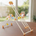 Toy structure made of interlocking pieces on a wooden surface with a blurred outdoor background