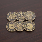 Set of six decorative coins with intricate designs on a wooden surface