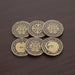 Set of six decorative coins with intricate designs on a wooden surface