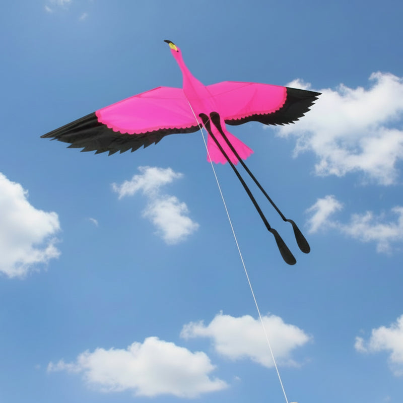 Pink flamingo kite with black wings on a blue sky background