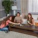 Three people playing a card game in a living room.