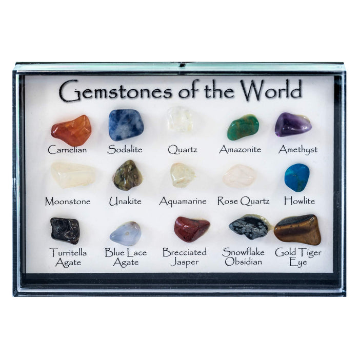 A gemstone display box labeled 'Gemstones of the World' containing 18 polished stones in a 3x6 grid with handwritten labels. The stones include various colors like orange, blue, green, purple, white, brown, and red, set in a clear glass case with a white backing.
