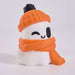 A cute ghost-shaped figurine wearing an orange knit beanie with a black pom-pom and an orange knit scarf, on a clean white background.