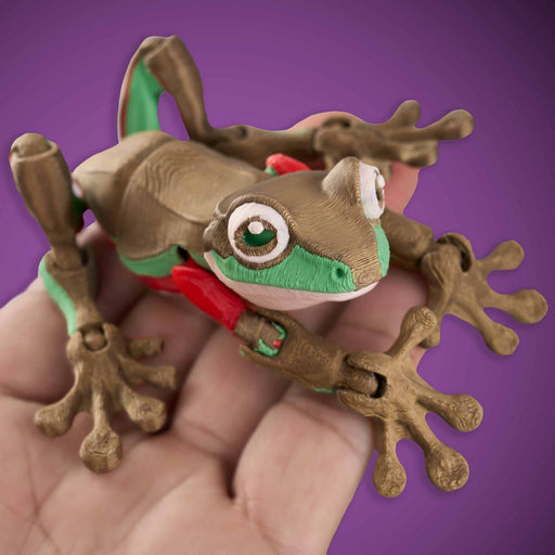 Toy frog on a hand with a purple background