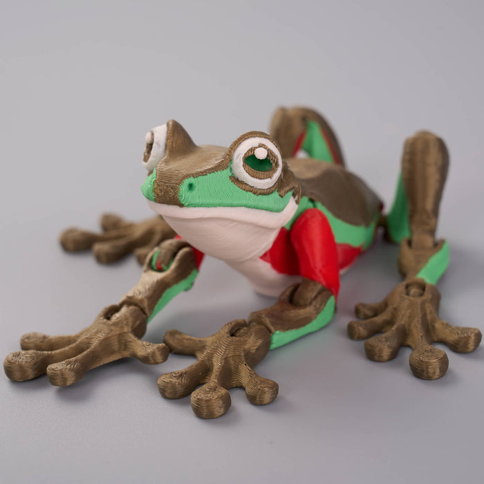 Toy frog with a red cape on a gray background