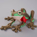 Toy frog with a red cape on a gray background