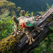 Plush toy frog on a log with a natural background