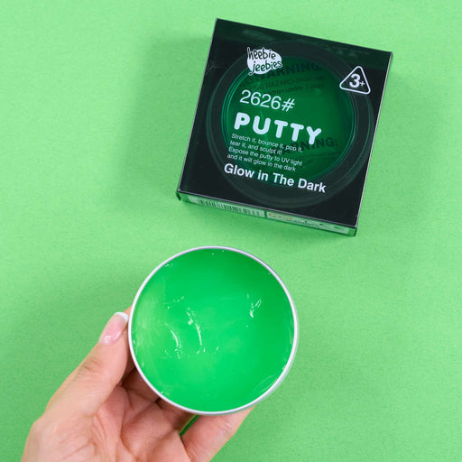 Green glow-in-the-dark putty with packaging on a green background