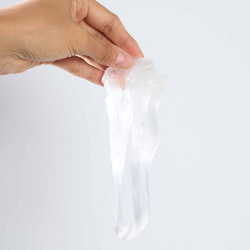 Hand holding a clear plastic putty against a white background