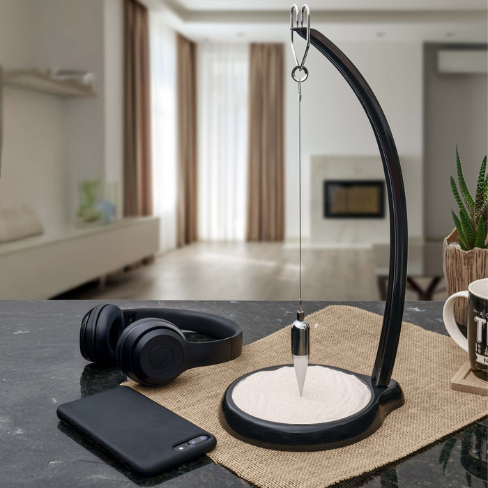 Modern Foucault Pendulum on desk  decorative items in a home office.