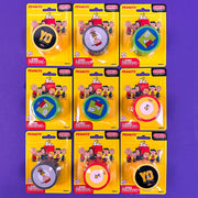 Set of eight 'Peanuts' yo yo duncan themed tape measures in packaging on a purple background