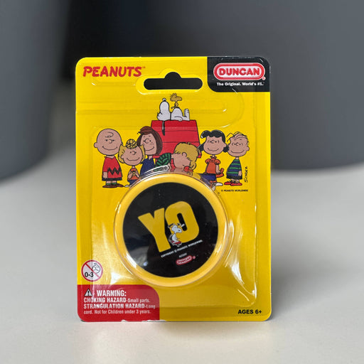 Yellow packaging of a Duncan yoyo with Peanuts character illustrations on a gray background