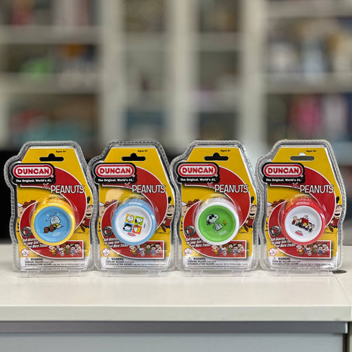 Four packages of Duncan Peanuts yo-yo toys on a shelf with a blurred store background.