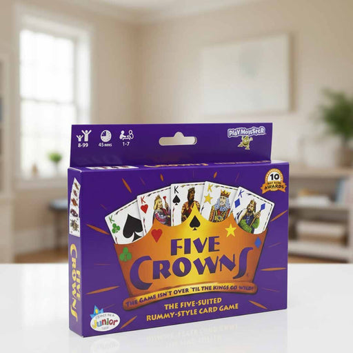 Card game box titled 'Five Crowns' by PlayMonster on a table with a blurred indoor background.