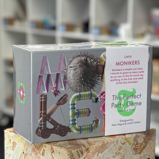 Box of 'Monikers' game with colorful letters and game description on a blurred background