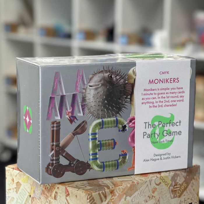 Box of 'Monikers' game with colorful letters and game description on a blurred background