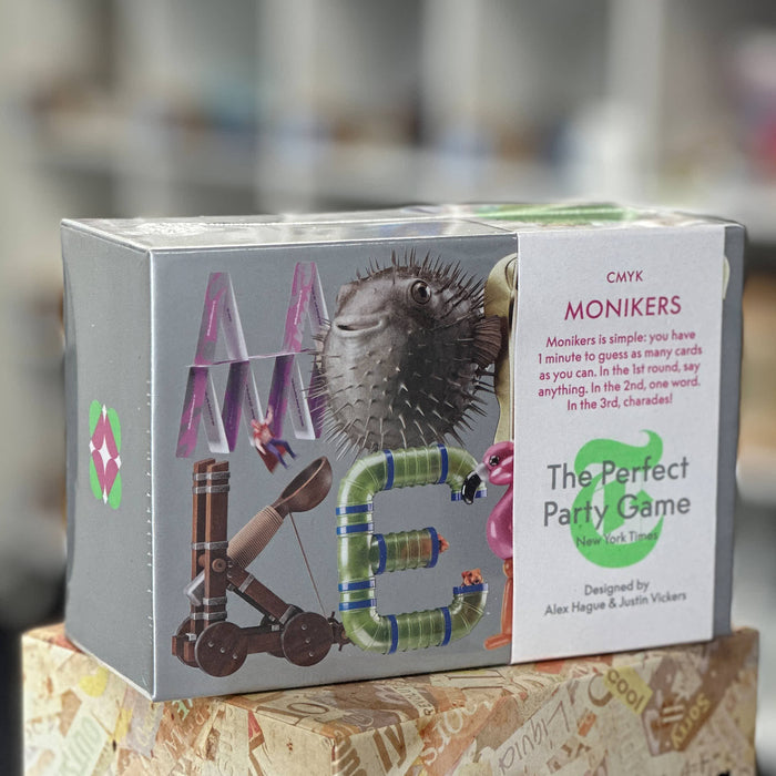 Box of 'Monikers' game with colorful letters and a puffer fish illustration on a blurred background