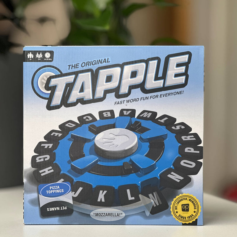 Tapple board game packaging with a hand-shaped spinner on a blurred background
