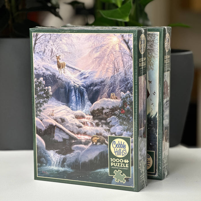 Cobble Hill puzzle box with a winter scene design on a white surface.