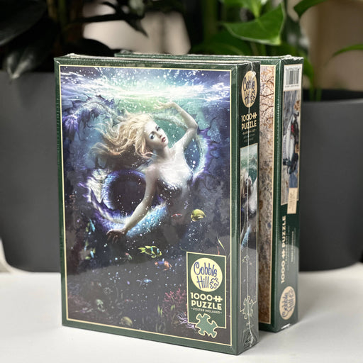 Jigsaw puzzle box with mermaid design on a white surface