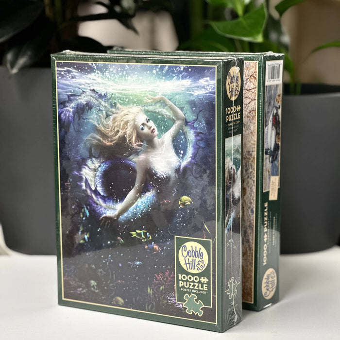 Jigsaw puzzle box with mermaid design on a white surface