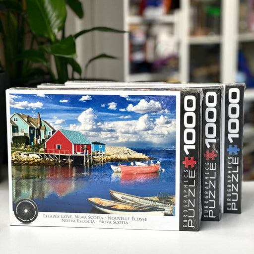 Two Eurographics 1000-piece puzzle boxes with a scenic design of Peggy's Cove, Nova Scotia.