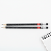 Two pencils with a ruler on top on a white background