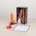 A toy rocket set on a light wood tabletop against a white wall, including an orange and purple rocket, its retail box, and an instruction sheet.