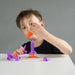 Child playing with toy rocket from heebie jeebies on a gray background